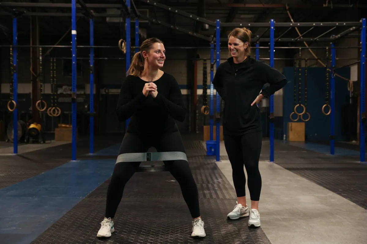 Kiley Robb, PT, DPT, coaches a runner through banded side steps in the gym