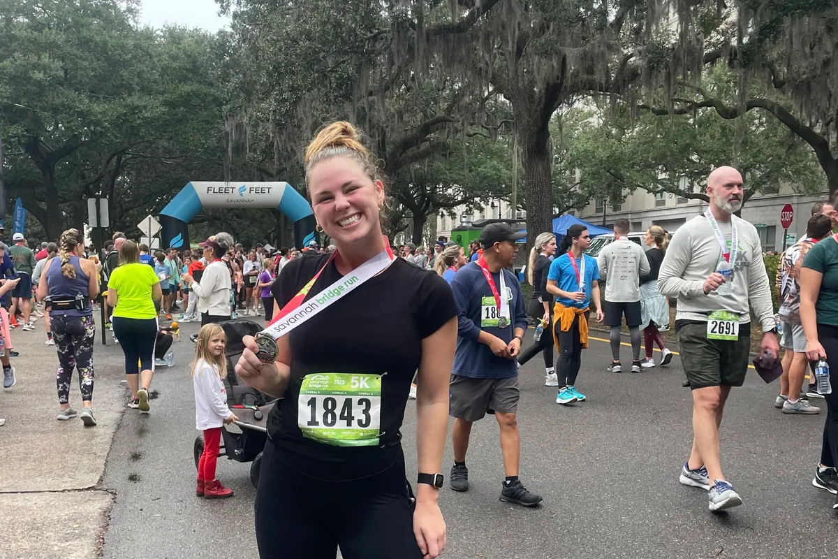 Kiley Robb, PT, DPT, CSCS, holds her finisher medal after the Savannah Bridge Run 5K