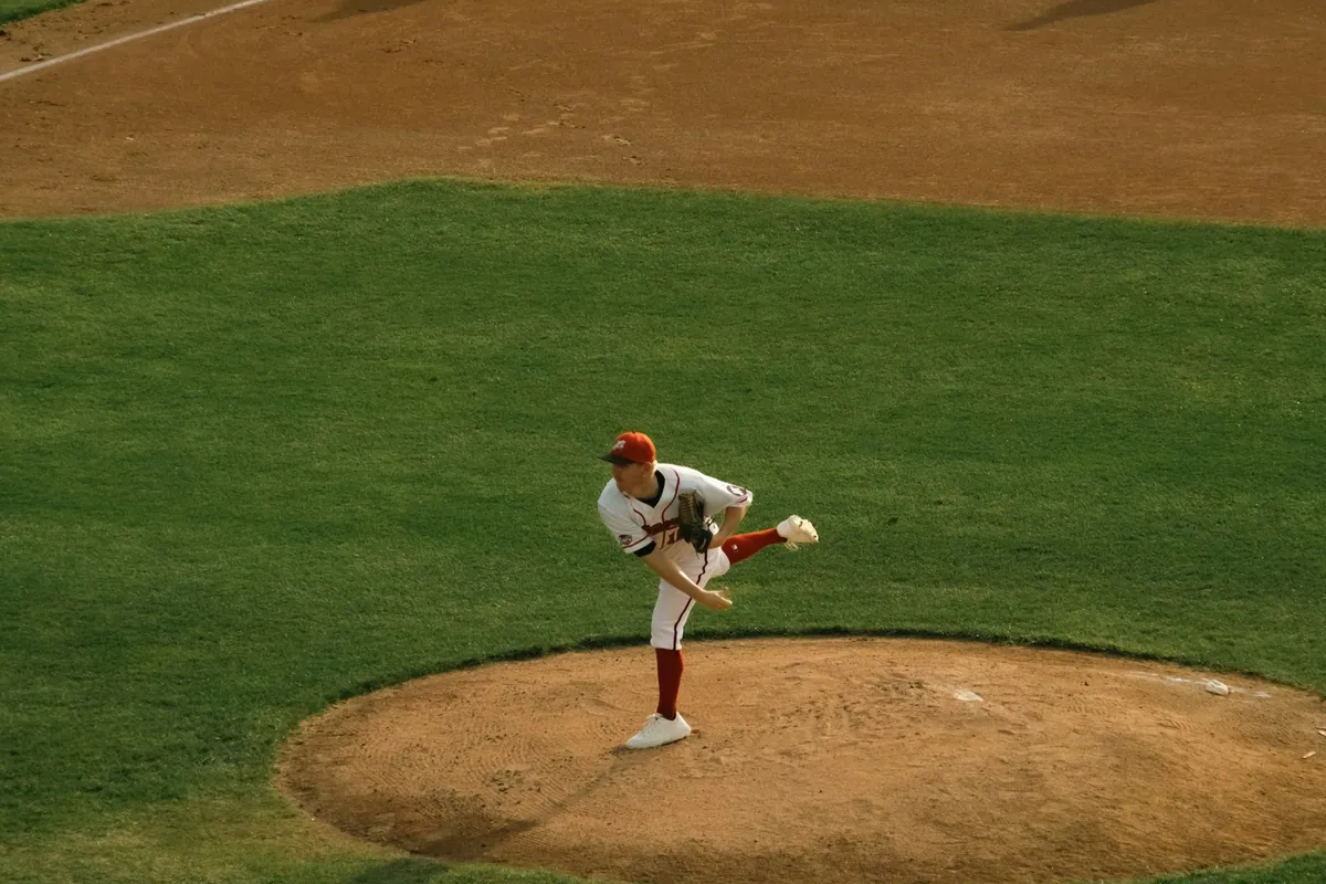 A baseball pitcher in the middle of a throw on the mound